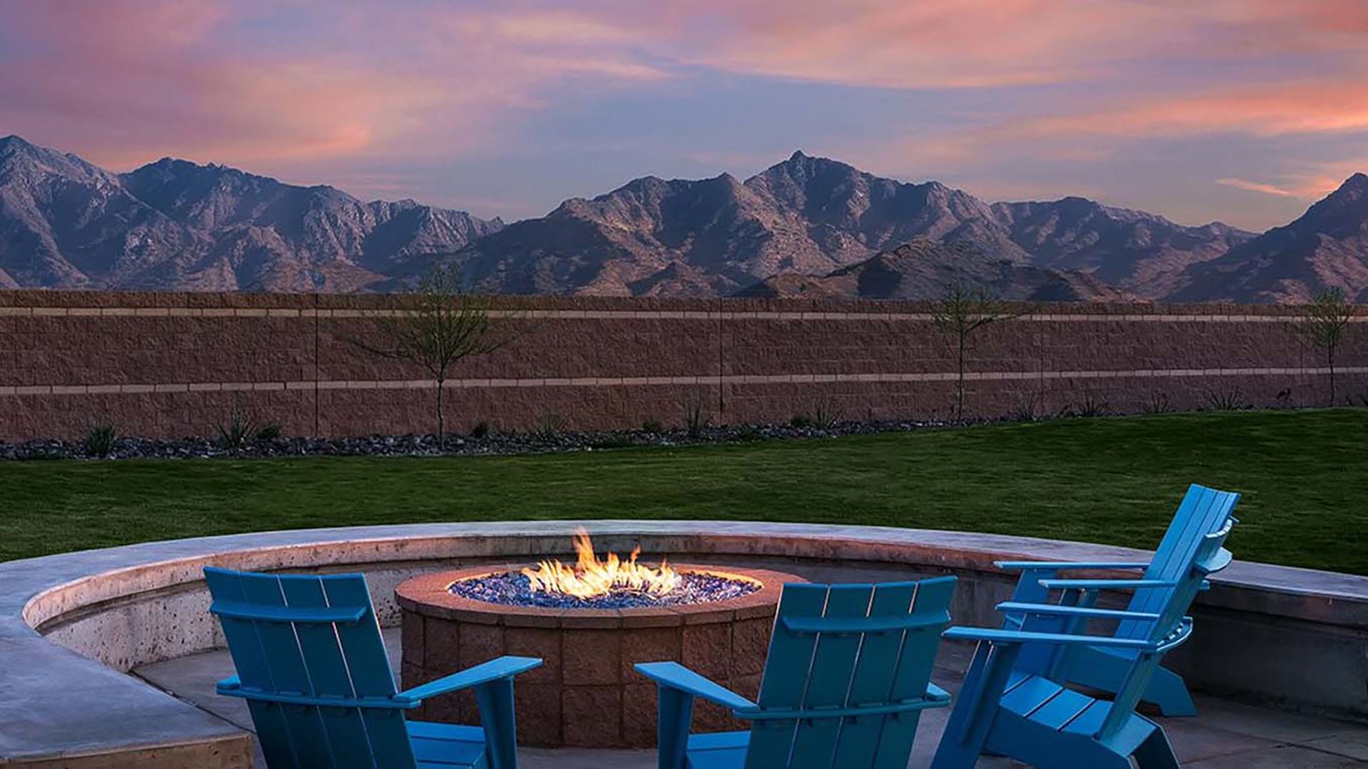 empty adirondack chairs and fire pit with mountain view