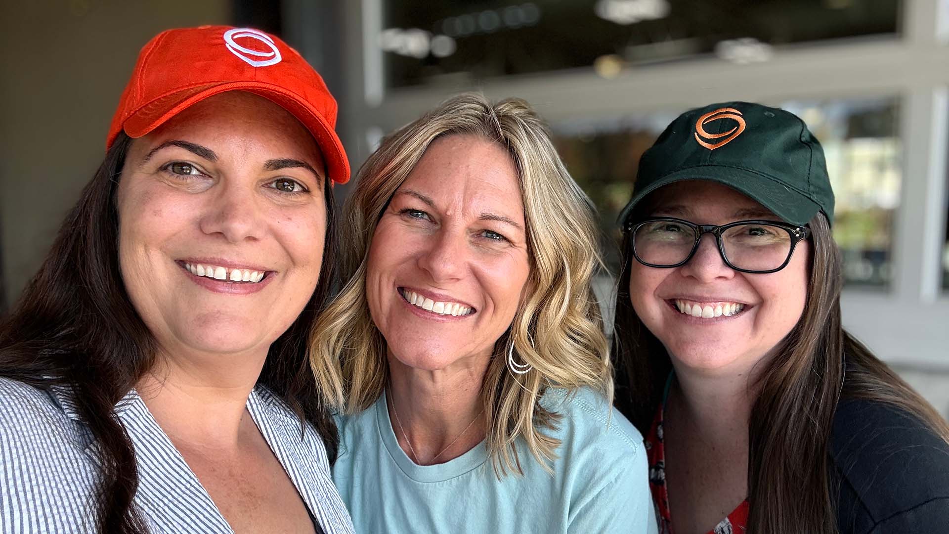 Three Cohere team members in Cohere swag.