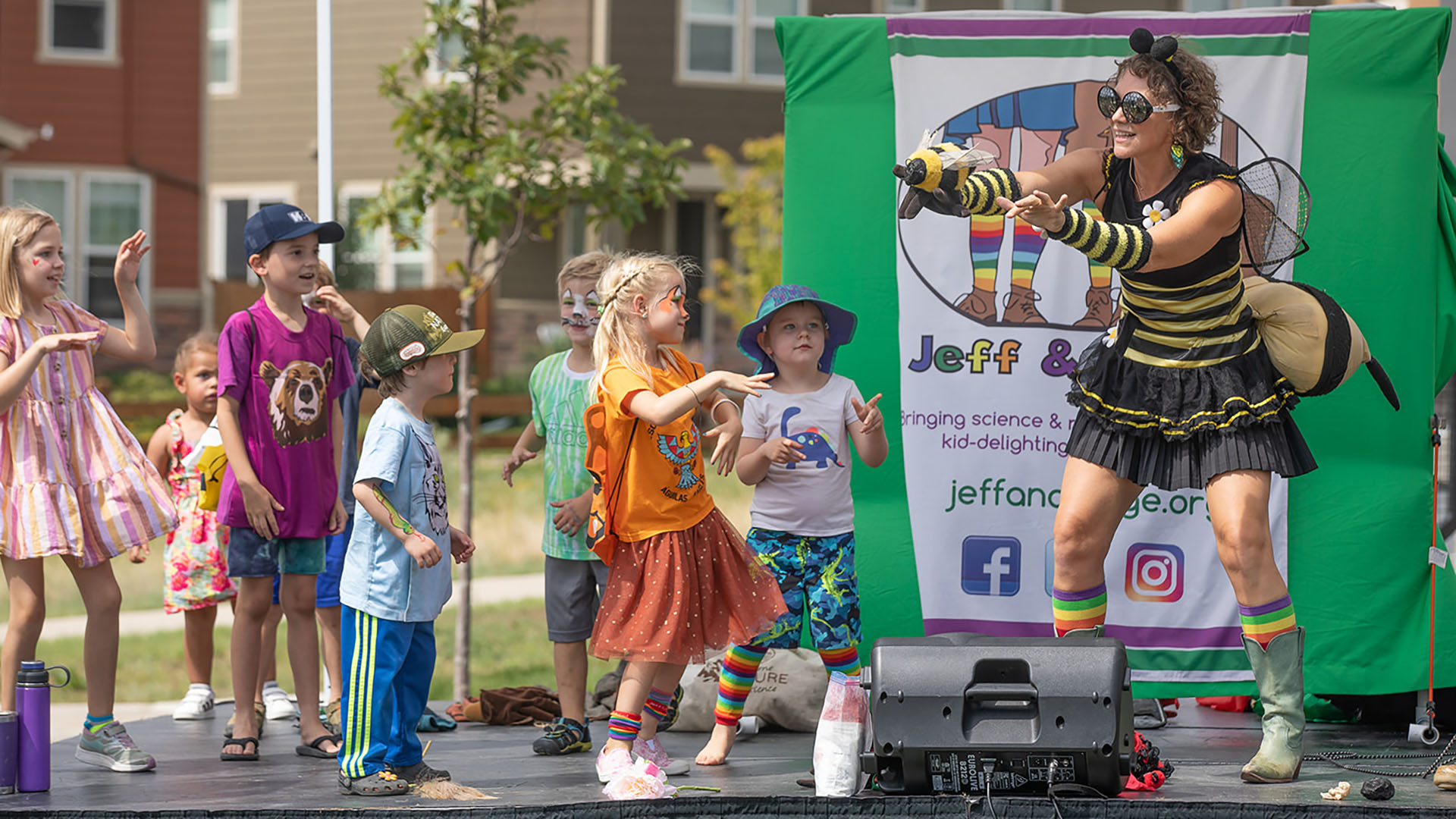 A woman in bee costume dancing with children at Baseline in Colorado